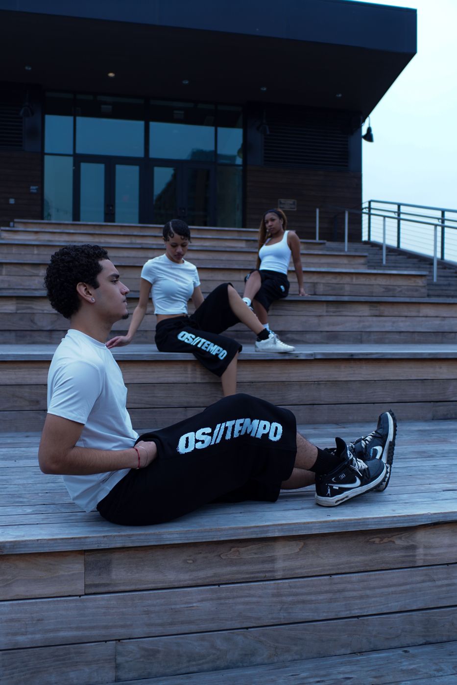 Models wearing OS//TEMPO shorts on wooden steps