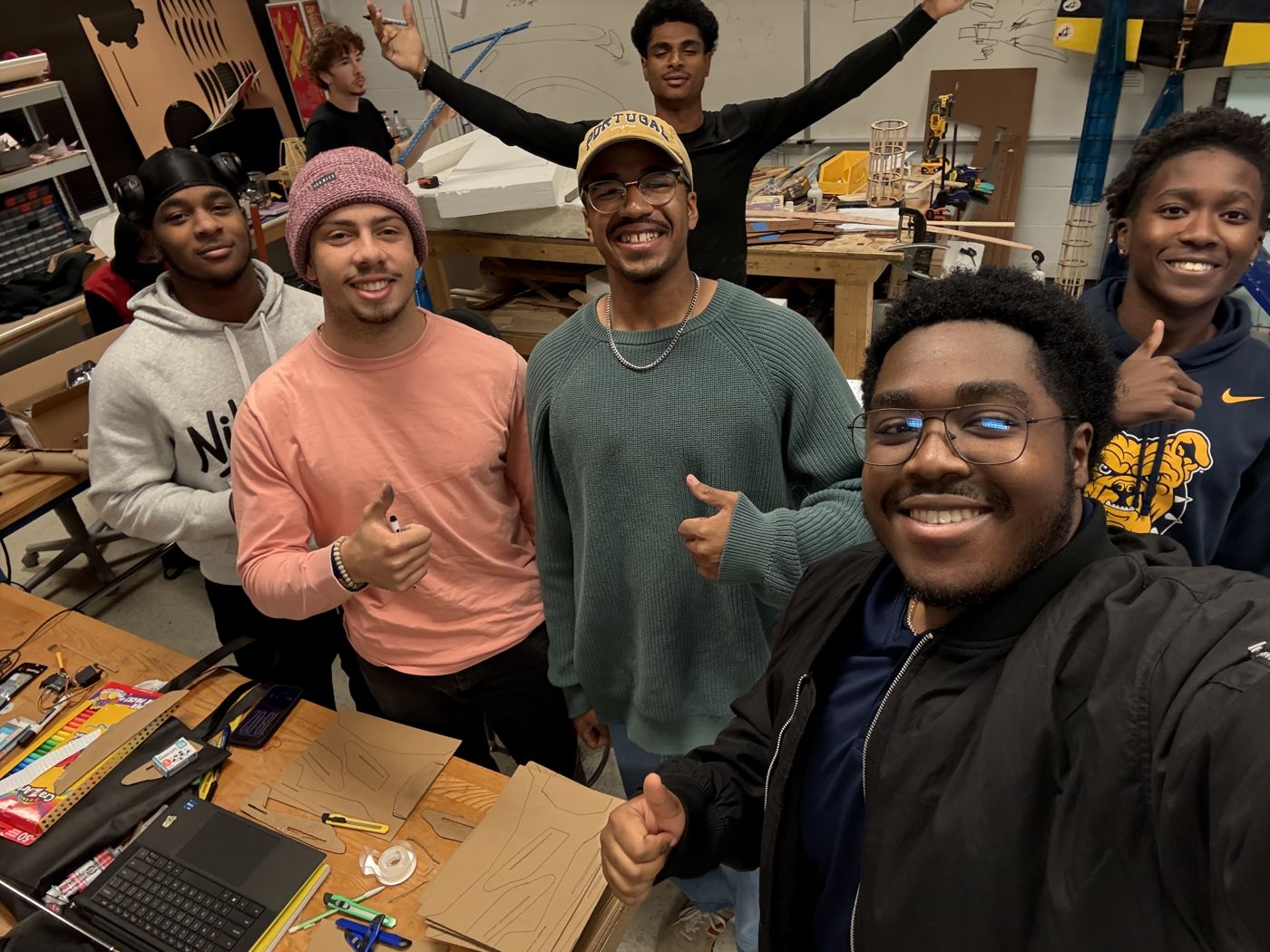 Group of students giving thumbs up in a workshop